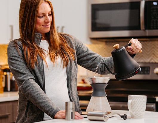 woman pouring coffee into brewing jug